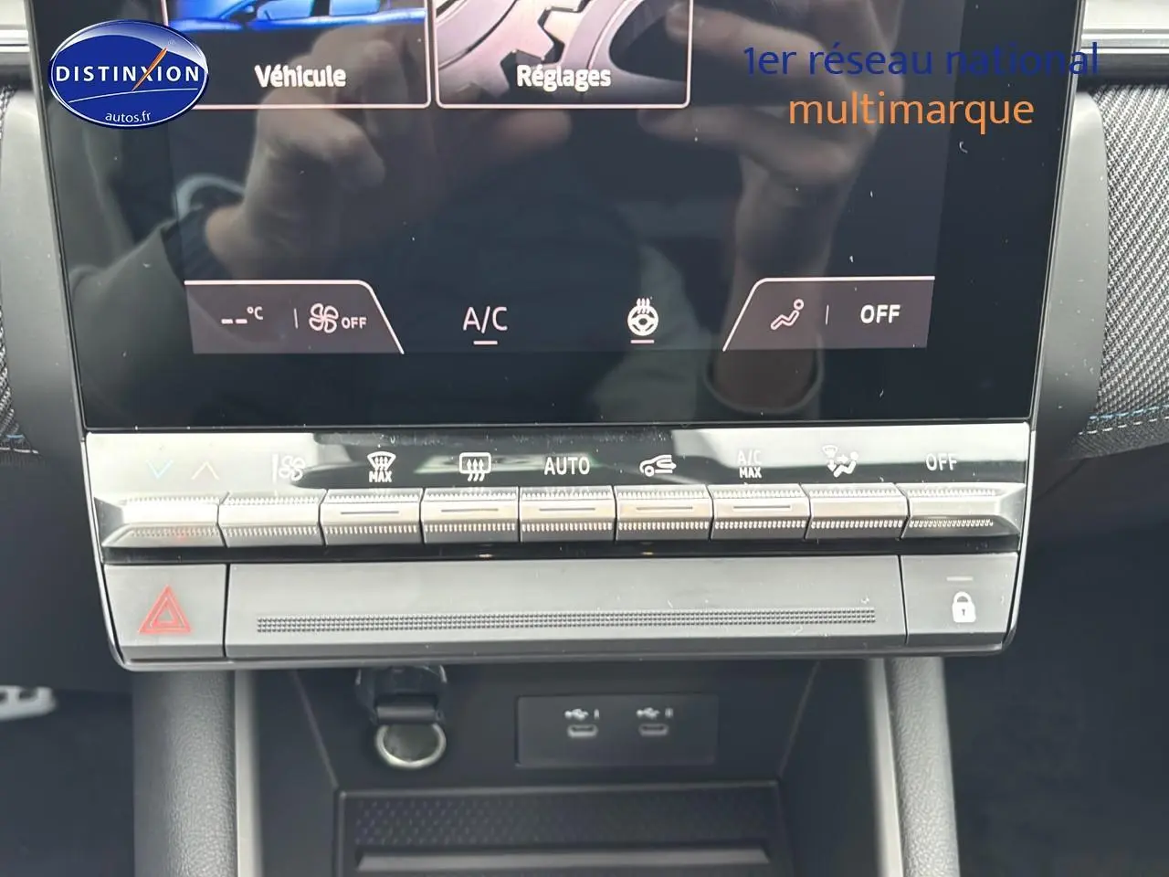 Gros plan sur la console centrale tactile et les commandes climatisation du Renault Captur gris rafale 2025.