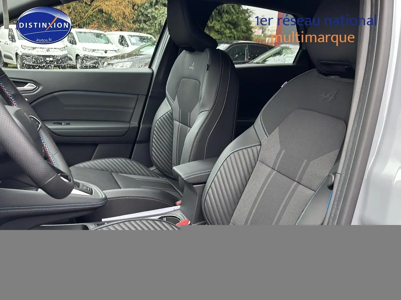 Vue intérieure côté conducteur du Renault Captur 1.8 e-tech gris rafale, sièges sport esprit Alpine avec surpiqûres bleues.