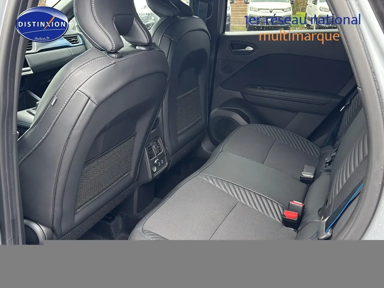 Vue intérieure arrière côté gauche du Renault Captur 2025 gris rafale, sièges noirs avec surpiqûres blanches.