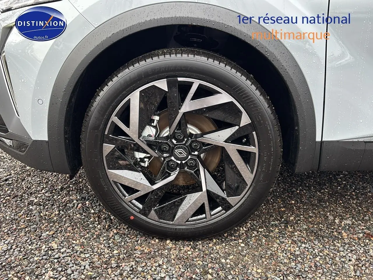 Gros plan sur la roue avant droite avec jante alu noire et argent du Renault Captur gris rafale.