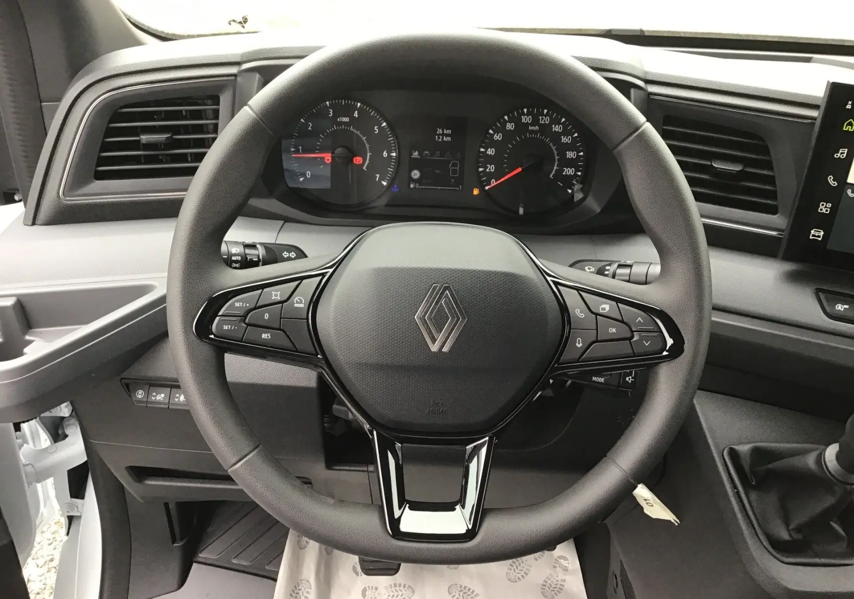 Vue rapprochée du volant noir du Renault Master blanc 2025, avec tableau de bord et commandes visibles.