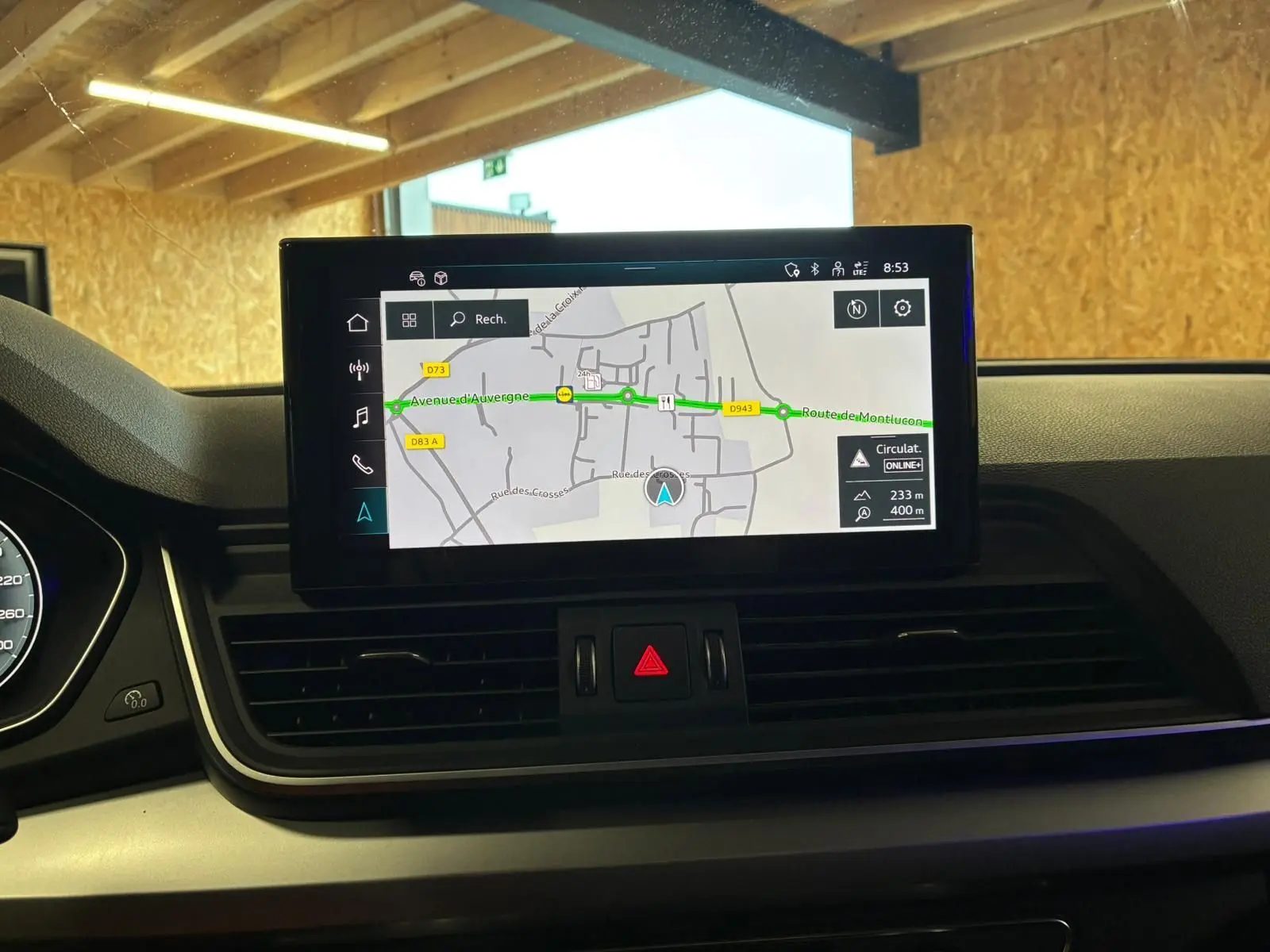 Vue intérieure centrée sur l'écran de navigation du tableau de bord de l'Audi Q5 gris 2024, affichant une carte routière.
