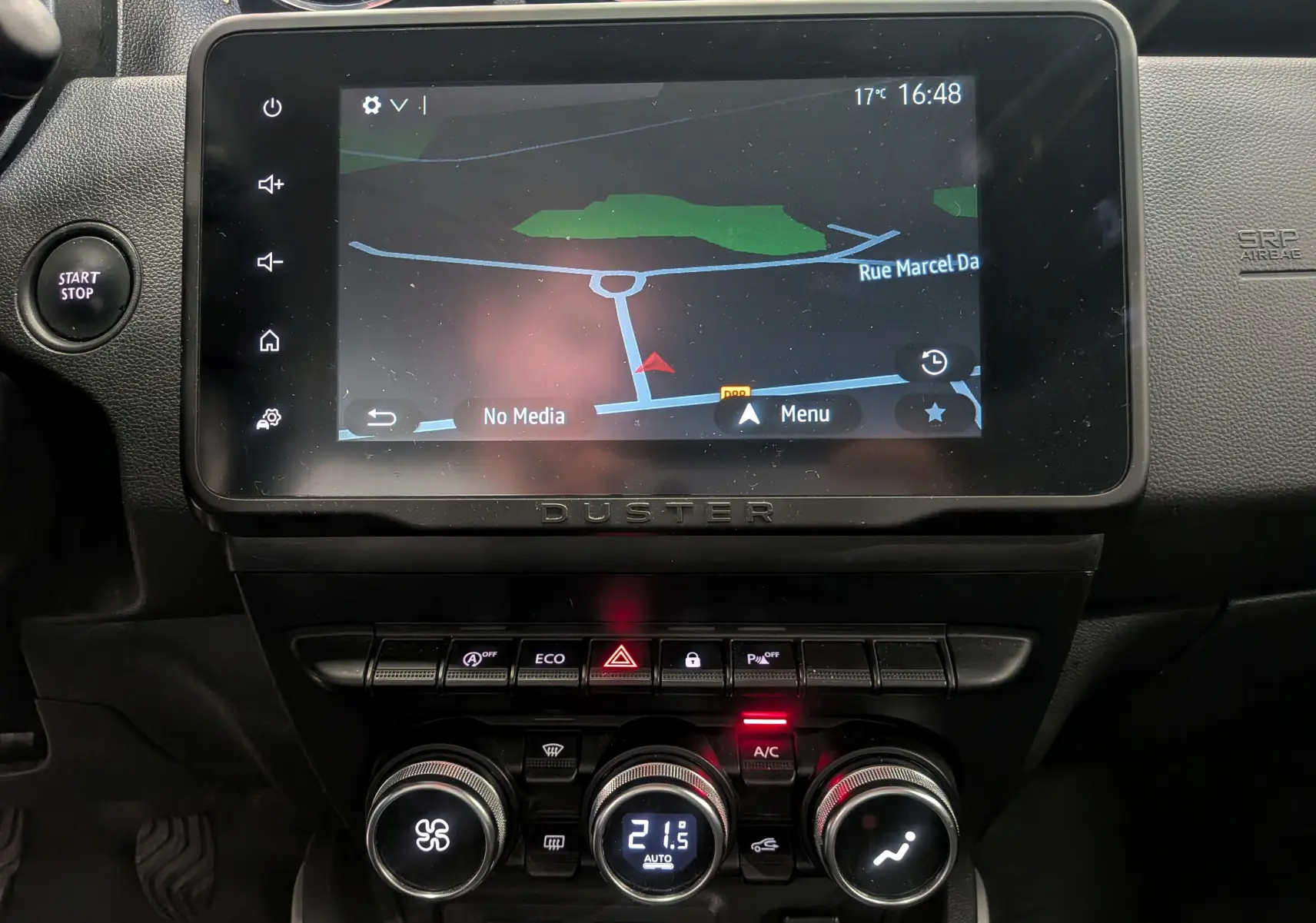 Vue rapprochée de la console centrale du Dacia Duster 2022 avec écran tactile et commandes de climatisation.