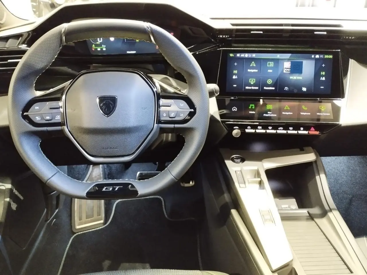 Vue intérieure centrée sur le volant GT noir et le tableau de bord numérique avec écran tactile de la Peugeot 308 gris Artense.