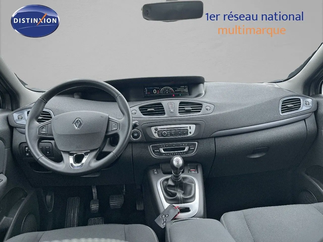 Intérieur avant du Renault Scénic III gris 2015, vue sur tableau de bord et volant avec boîte manuelle.