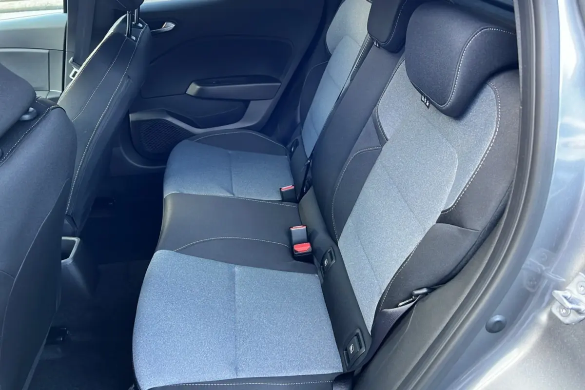 Vue intérieure sur la banquette arrière bi-ton gris clair et noir de la Renault Clio 2025, porte ouverte côté droit.