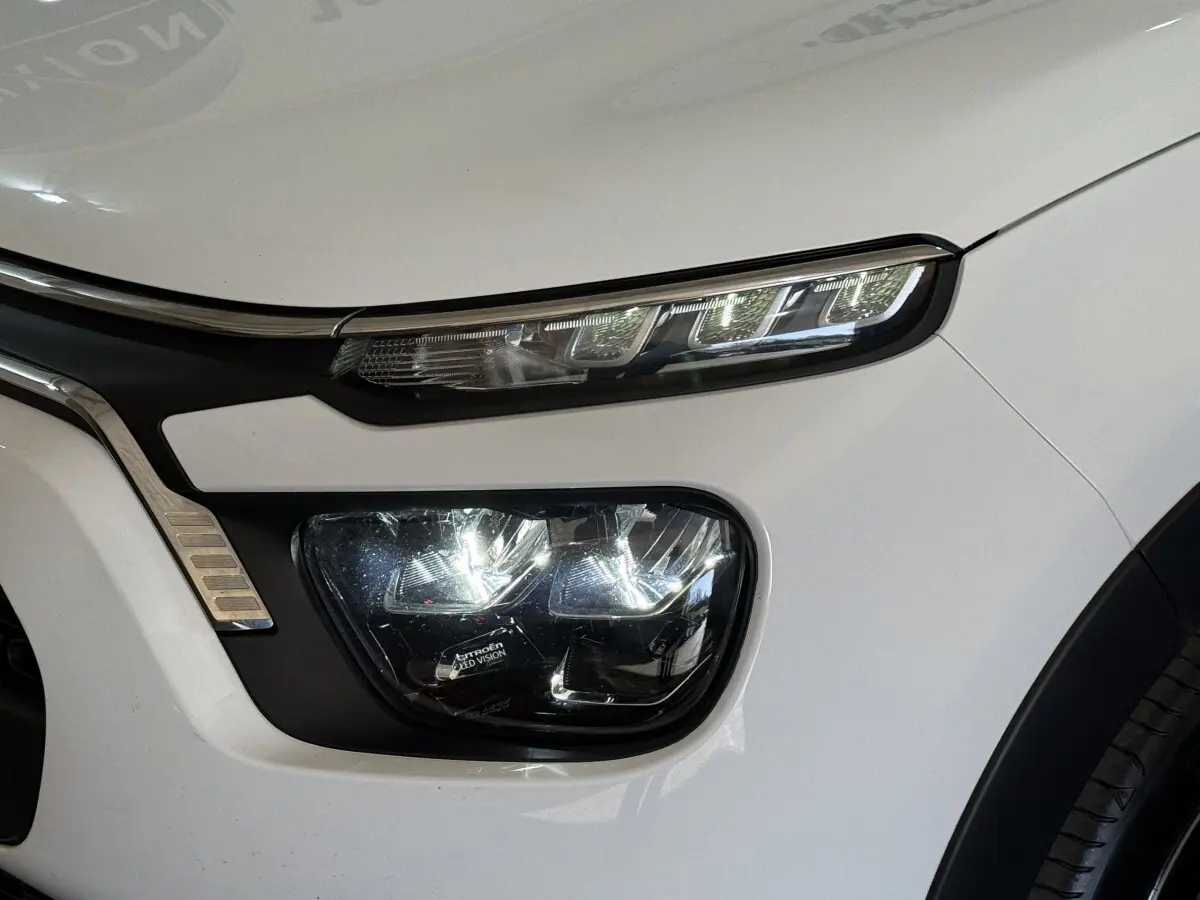 Gros plan sur le phare avant droit blanc de la Citroën C3 2021 avec feux LED distinctifs et détails chromés.