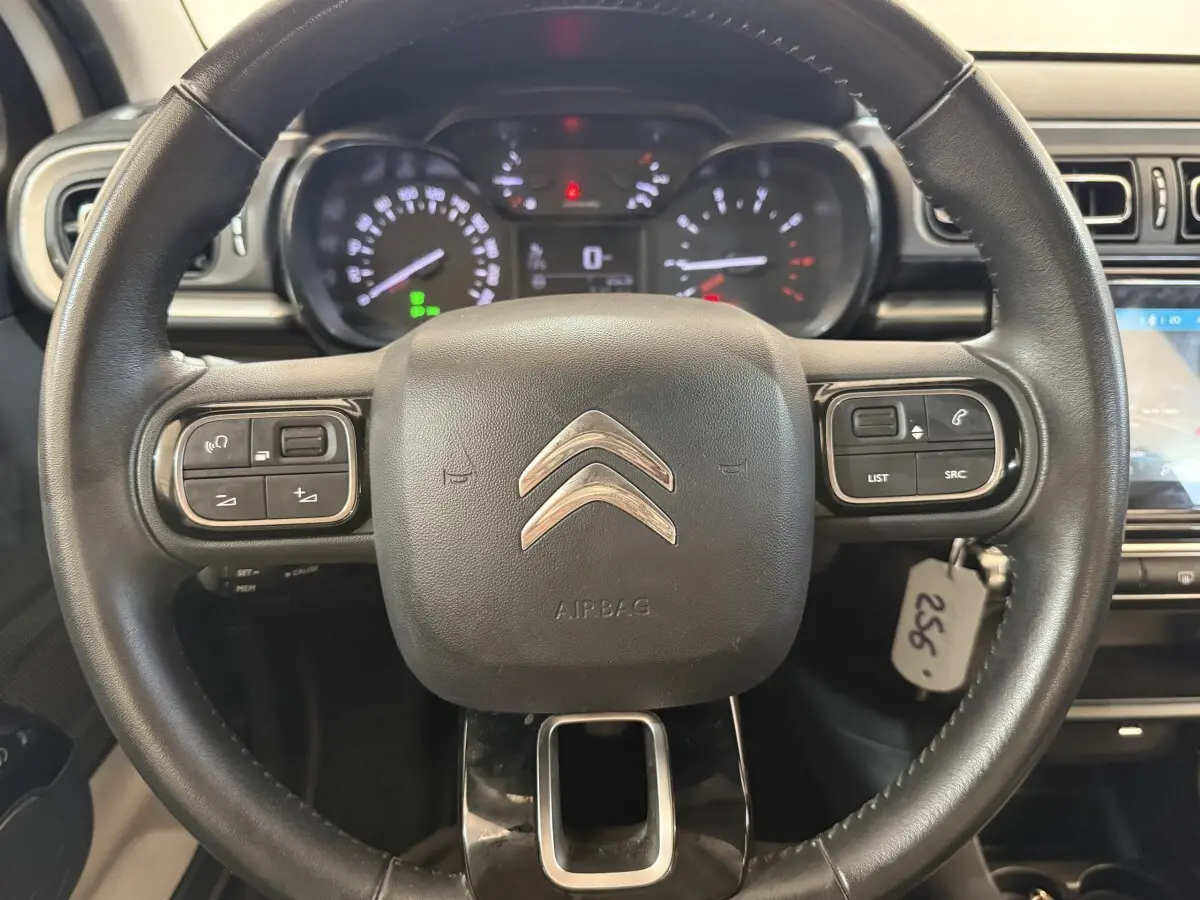 Vue rapprochée du volant cuir noir de la Citroën C3 2021 avec commandes intégrées et tableau de bord digital.