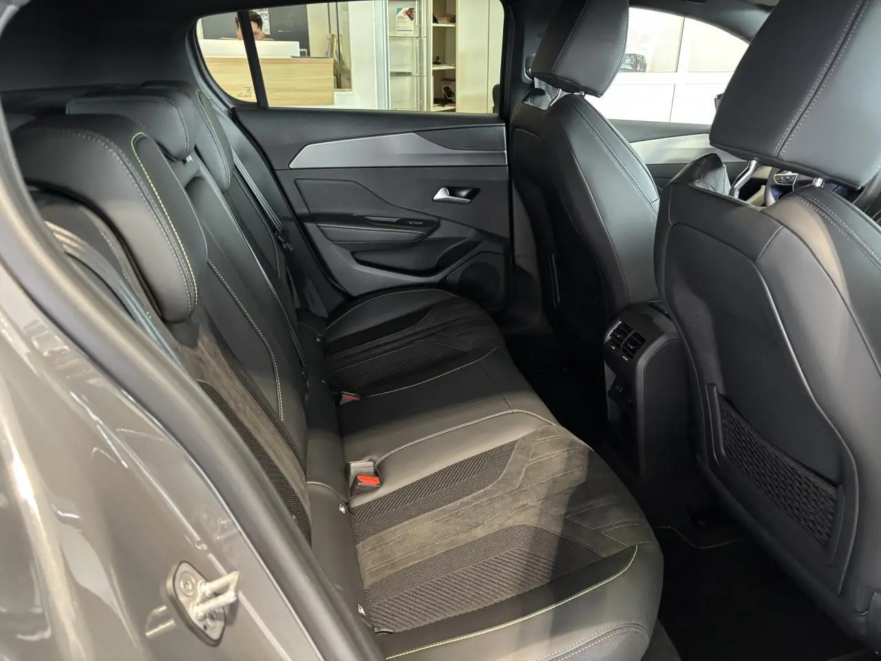 Vue intérieure côté gauche montrant la banquette arrière en Alcantara noir avec surpiqûres vert Adamite du Peugeot 308 gris selenium.
