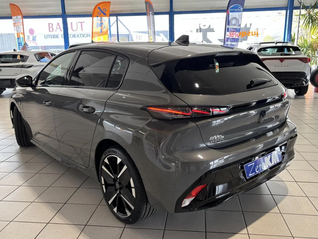 Vue 3/4 arrière droite d'une Peugeot 308 gris sélénium avec feux arrière LED 3 griffes et jantes alliage bi-tons.