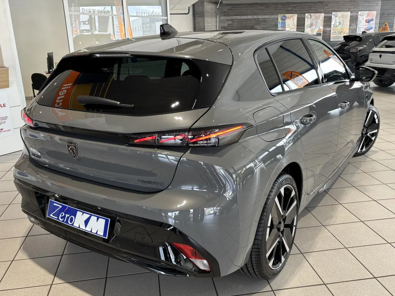Vue 3/4 arrière droite d’une Peugeot 308 hybride gris selenium avec feux arrière LED et jantes alliage bi-tons.