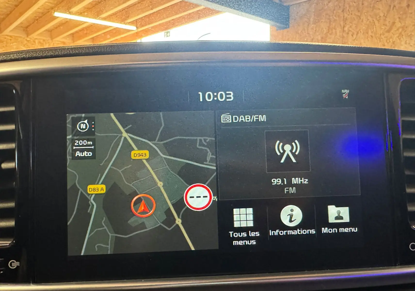 Écran tactile du système de navigation et radio DAB/FM affichant une carte et fréquence 99,1 MHz dans un Kia Sportage.