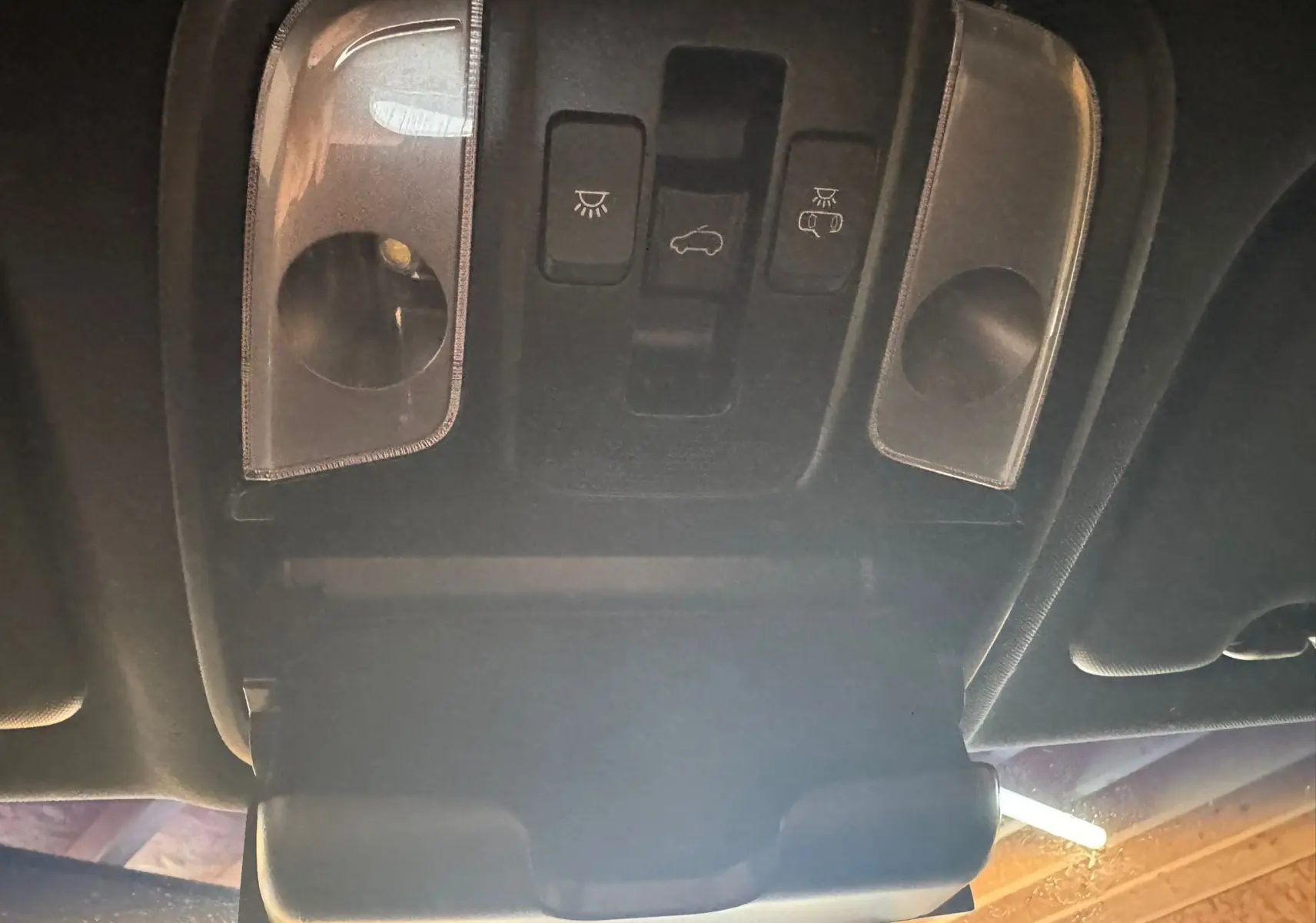 Vue intérieure en plongée du plafonnier avec commandes d'éclairage et rangement lunettes du Kia Sportage rouge 2019.