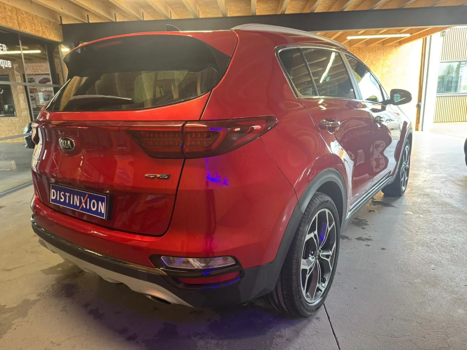 Vue 3/4 arrière droite d'un KIA Sportage rouge 2019 GT Line avec jantes alliage et feux arrière LED.