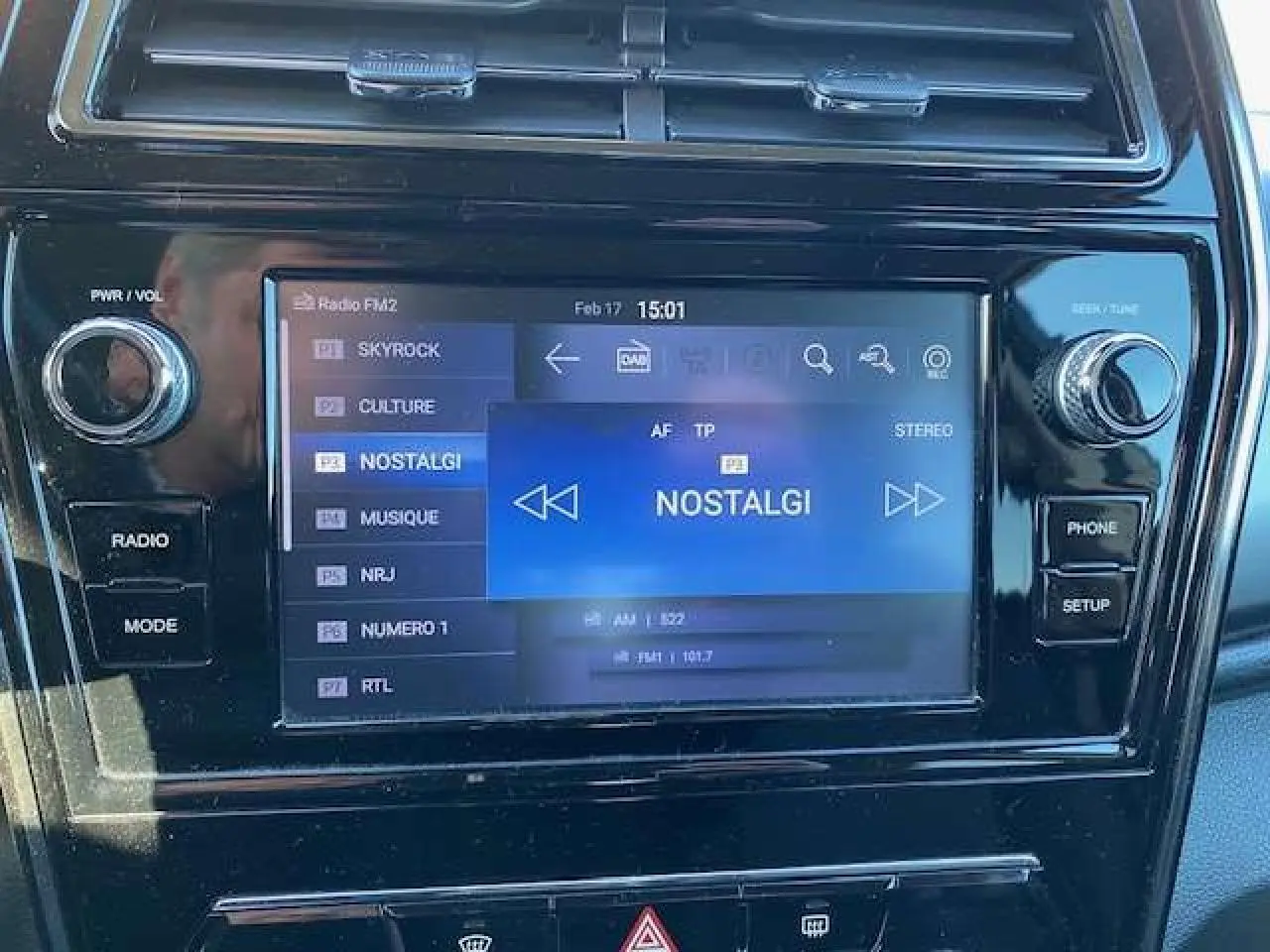 Gros plan sur l'écran tactile central du SsangYong Tivoli 2021 avec interface radio et commandes autour en noir brillant.