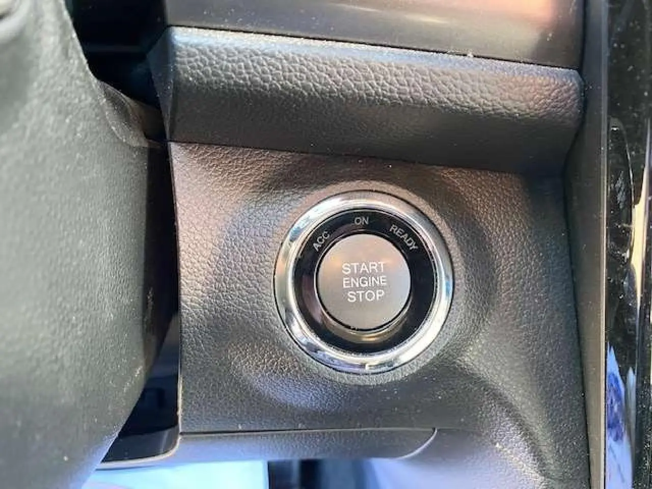 Gros plan sur le bouton Start Engine Stop entouré de chrome dans l'habitacle du SsangYong Tivoli 2021 gris foncé.