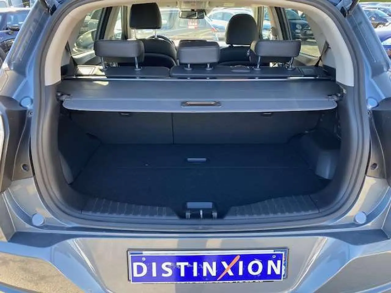 Coffre ouvert vu de l'arrière d'un SsangYong Tivoli gris foncé, montrant l'espace de chargement et les appuie-têtes arrière.