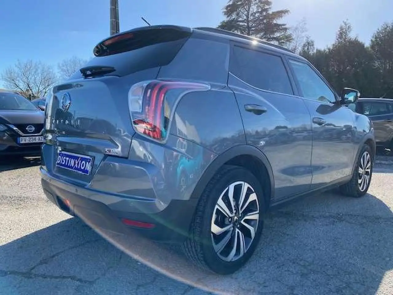 Vue 3/4 arrière droite d'un SsangYong Tivoli gris foncé avec jantes alliage et vitres arrière surteintées.
