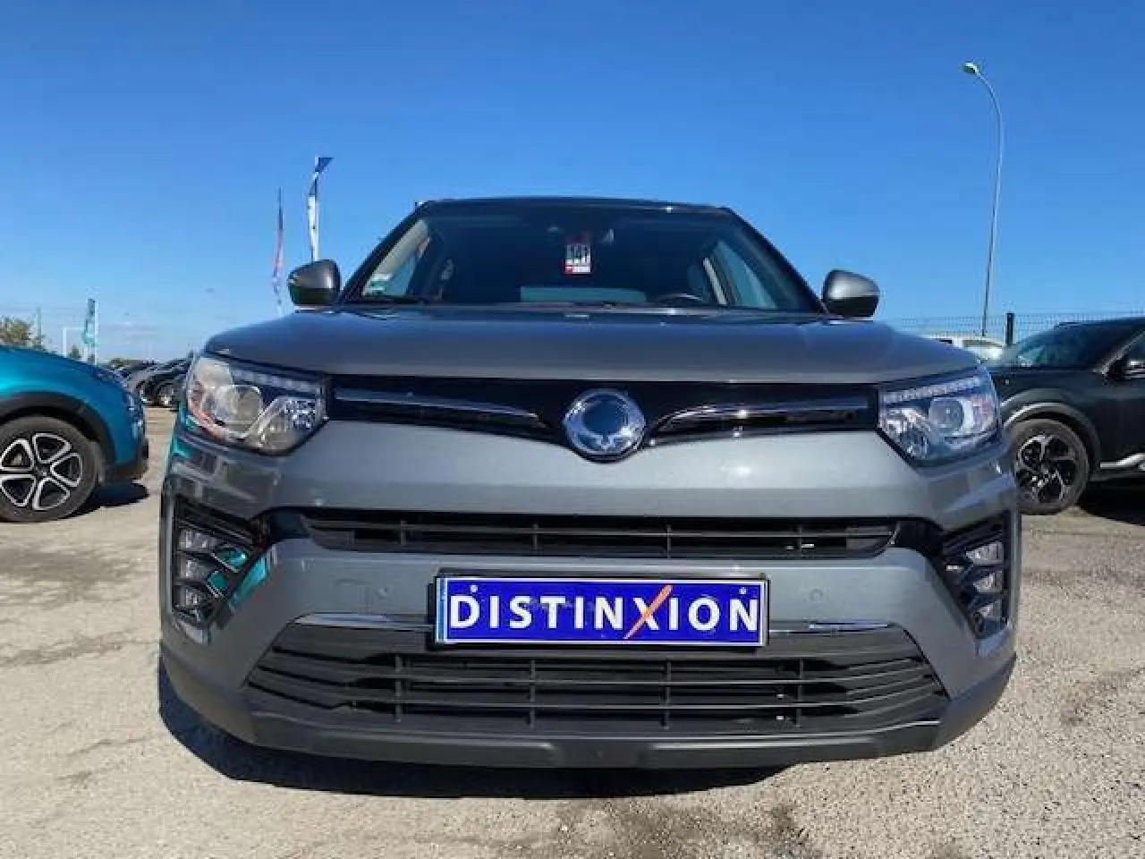 Vue de face d'un SsangYong Tivoli gris foncé avec calandre noire et plaque d'immatriculation Distinxion.