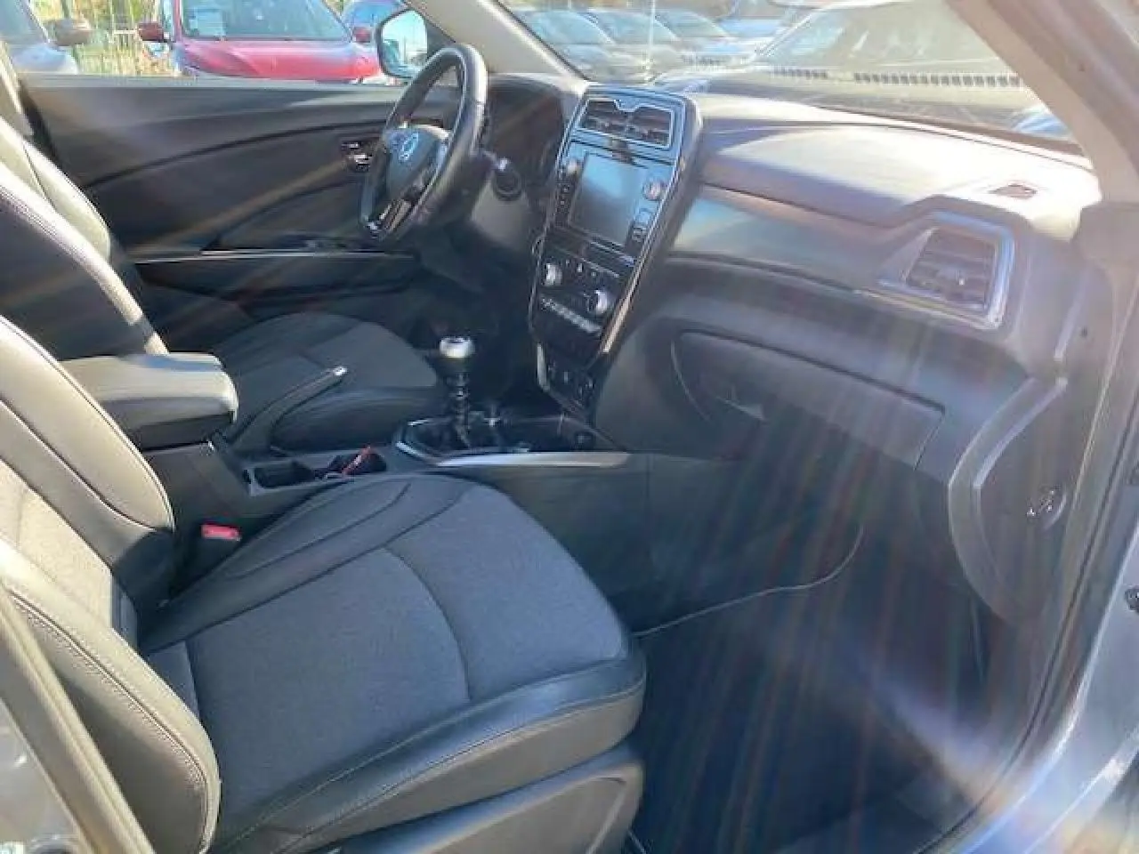 Vue intérieure côté conducteur du SsangYong Tivoli 2021, montrant sièges noirs, volant cuir et console centrale avec écran tactile.