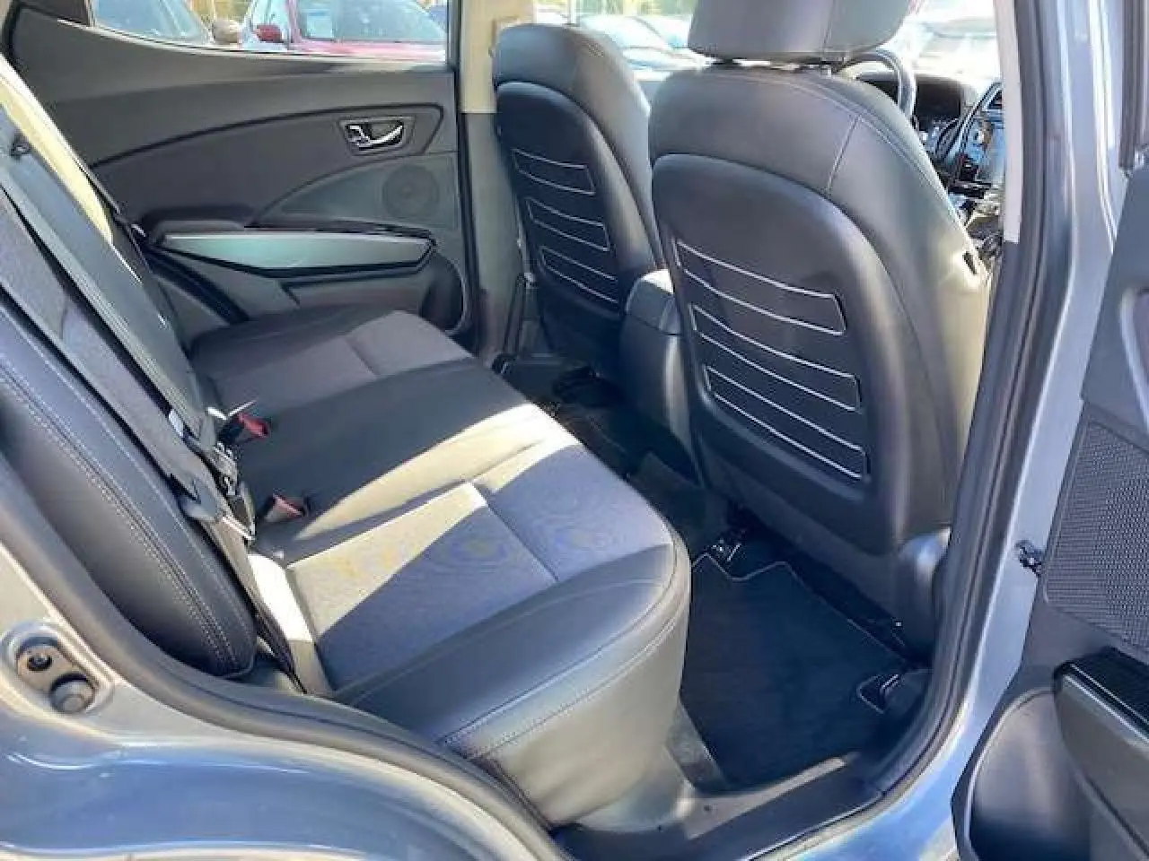 Vue intérieure arrière droite du SsangYong Tivoli gris foncé 2021, montrant les sièges et panneaux de porte en cuir noir.