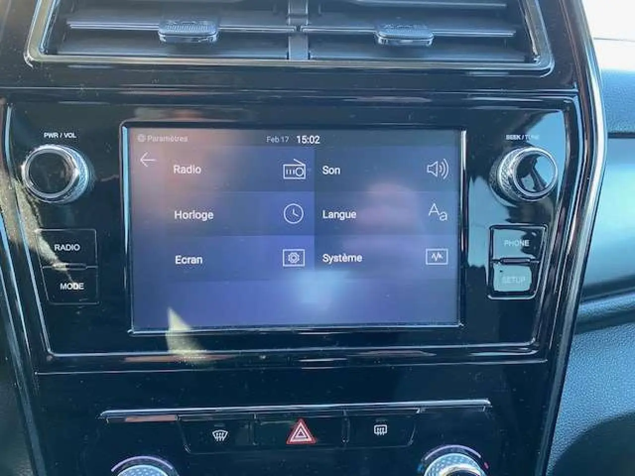 Écran tactile central du SsangYong Tivoli 2021 affichant les réglages radio, son et système, entouré de commandes noires brillantes.