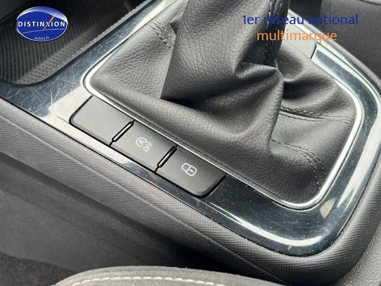 Gros plan sur la console centrale noire avec levier de vitesses cuir et boutons de verrouillage dans une Skoda Fabia bleue 2025.