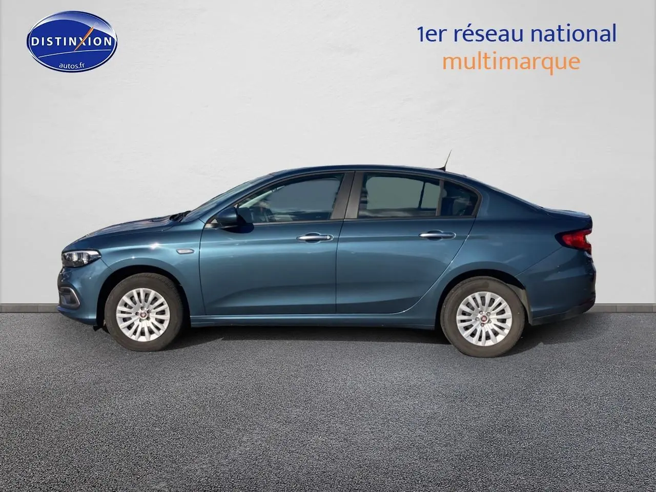 Profil côté gauche d'une Fiat Tipo 1.6 Multijet bleu 2024 avec enjoliveurs blancs sur fond neutre.