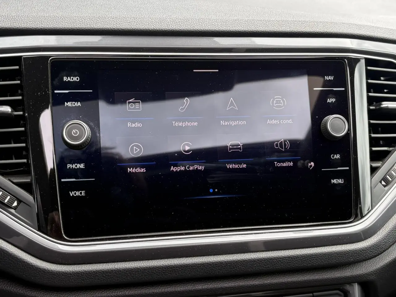 Vue rapprochée de l'écran tactile central du Volkswagen T-Roc 1.5 TSI 2021, affichant les options multimédia et navigation.