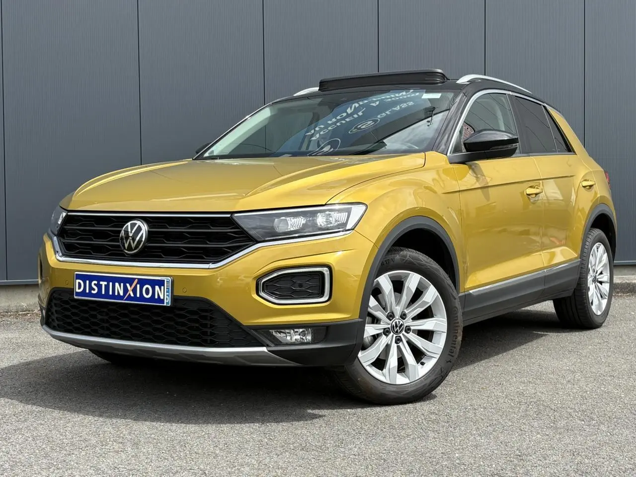 Volkswagen T-Roc 1.5 TSI jaune curcuma vue 3/4 avant avec toit noir et jantes alliage 17 pouces.