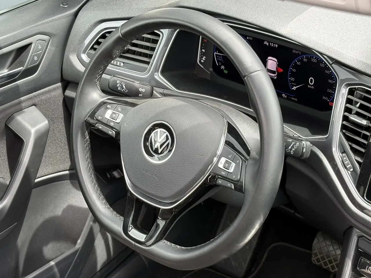 Vue rapprochée du volant multifonction en cuir noir et du tableau de bord numérique du Volkswagen T-Roc 2021.