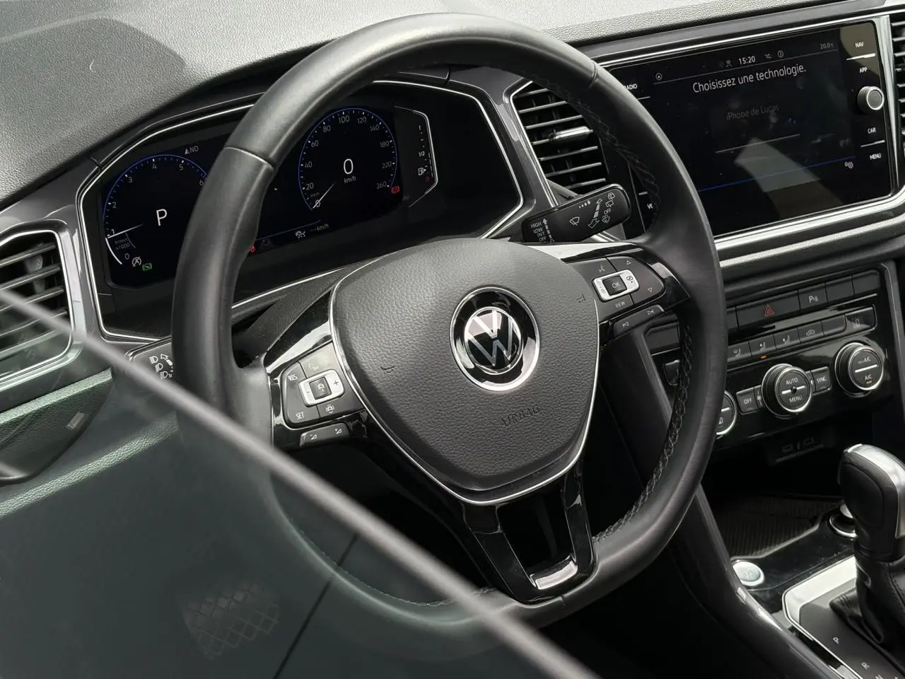 Vue rapprochée de l’intérieur du Volkswagen T-Roc 1.5 TSI 2021, volant multifonction en cuir et tableau de bord digital.