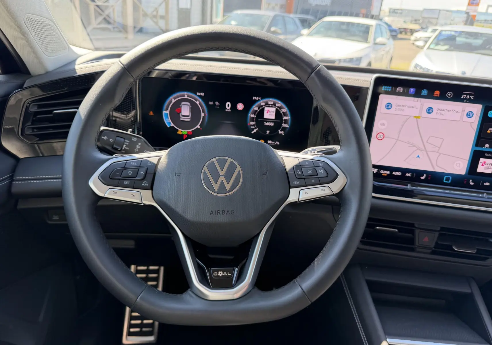 Vue intérieure centrée sur le volant cuir multifonction du Volkswagen Tiguan 2025 avec tableau de bord numérique et écran tactile.