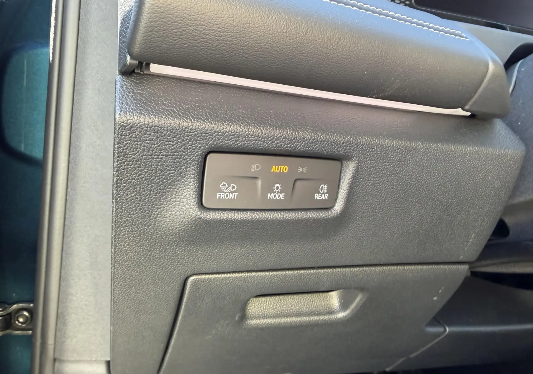Détail du panneau de commande des feux avec mode automatique sur Volkswagen Tiguan 2.0 TDI bleu, côté gauche intérieur.