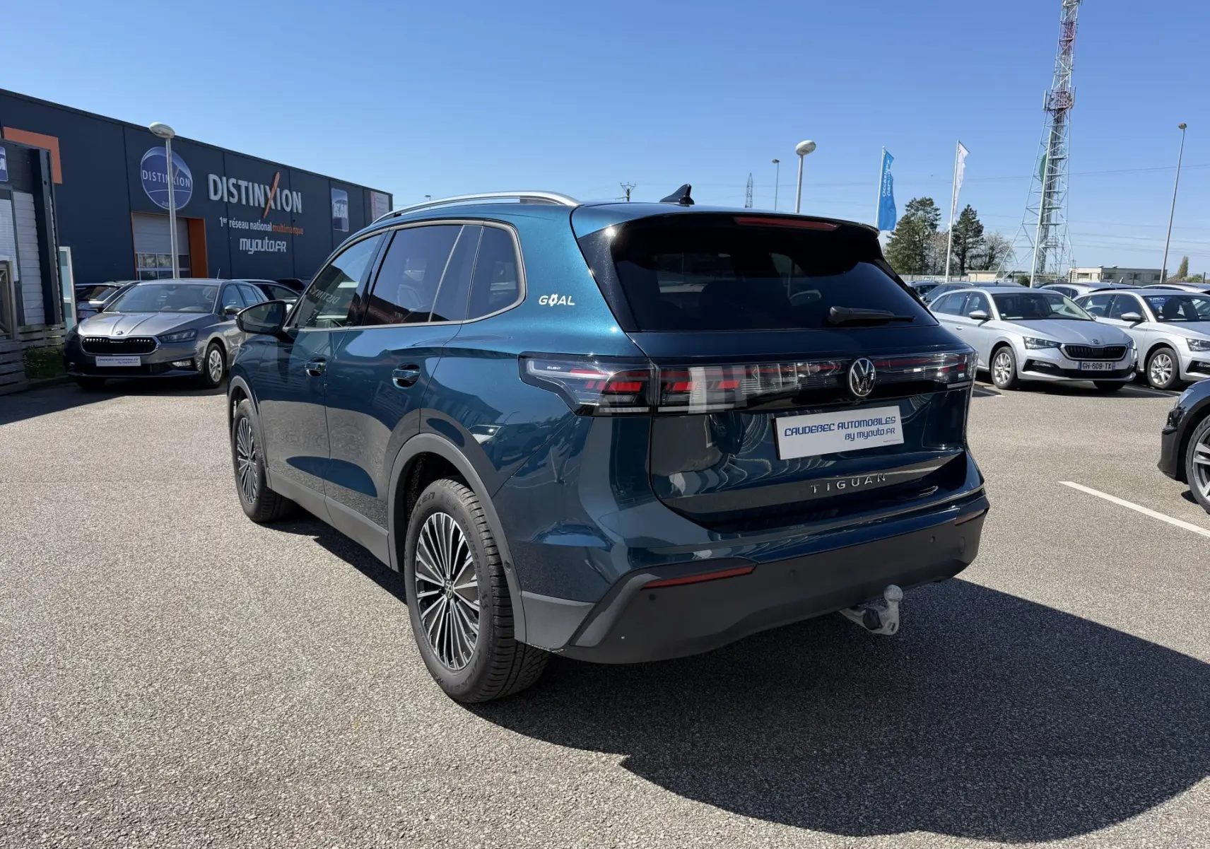 Volkswagen Tiguan bleu en 3/4 arrière droit avec crochet d'attelage escamotable et jantes alliage 18 pouces.