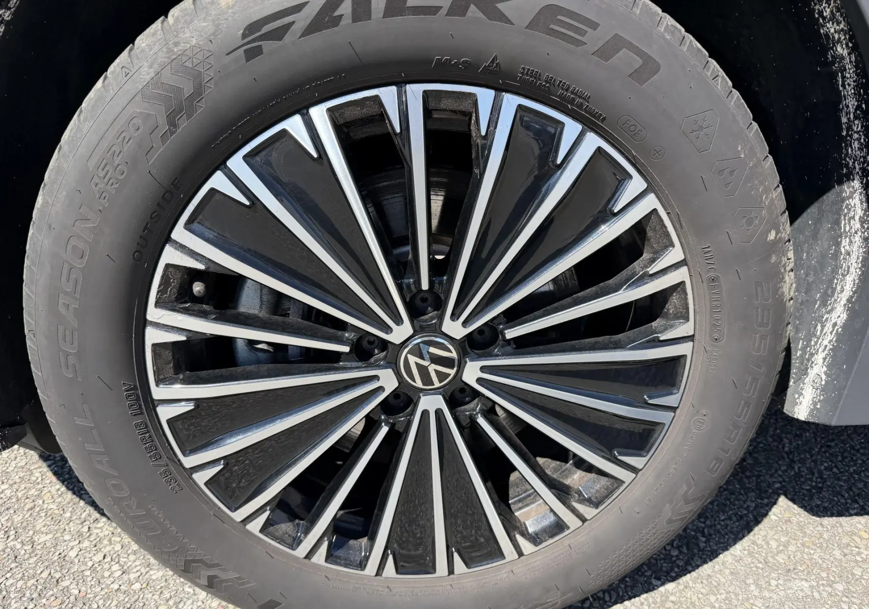 Gros plan sur la jante alliage 18 pouces Napoli noire et argentée du Volkswagen Tiguan bleu, avec pneu Falken 235/55 R18.