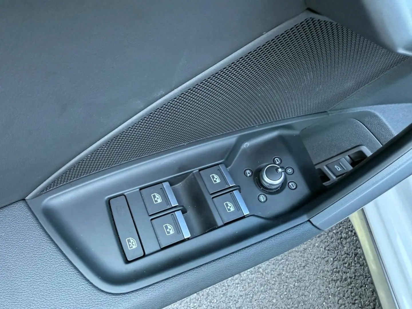 Gros plan sur les commandes des vitres et rétroviseurs côté conducteur de l'Audi A3 Sportback blanc Glacier 2025.