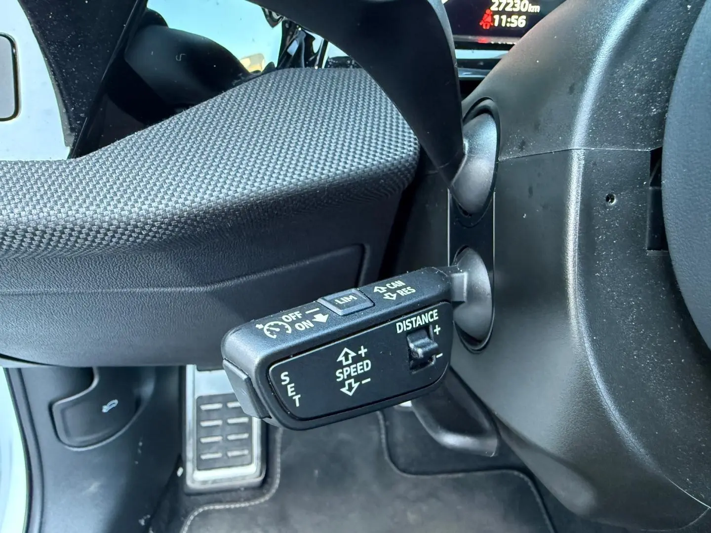 Gros plan sur la commande de régulateur de vitesse au volant d’un Audi A3 Sportback blanc Glacier métallisé.