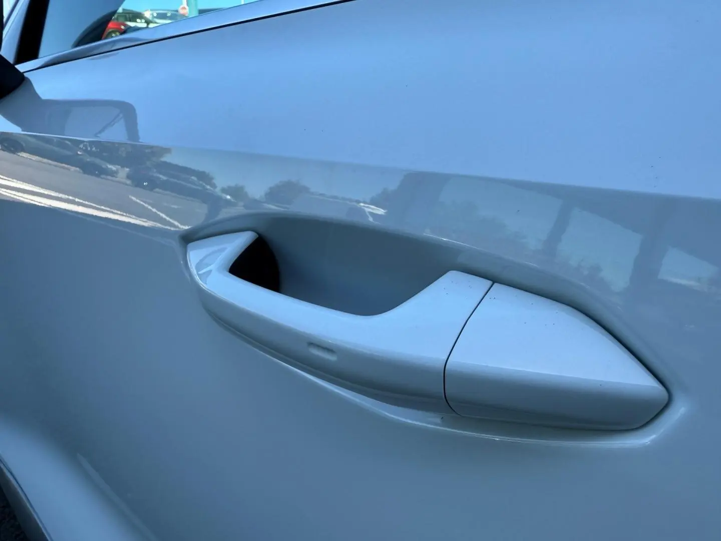 Poignée de porte blanche Glacier métallisé en gros plan sur le côté gauche d'une Audi A3 Sportback 2025.