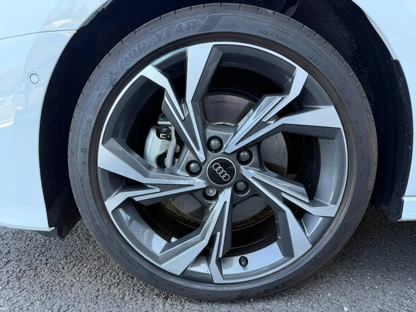 Gros plan sur la jante alu gris anthracite à design sportif de l'Audi A3 Sportback blanc glacier métallisé, roue avant droite.