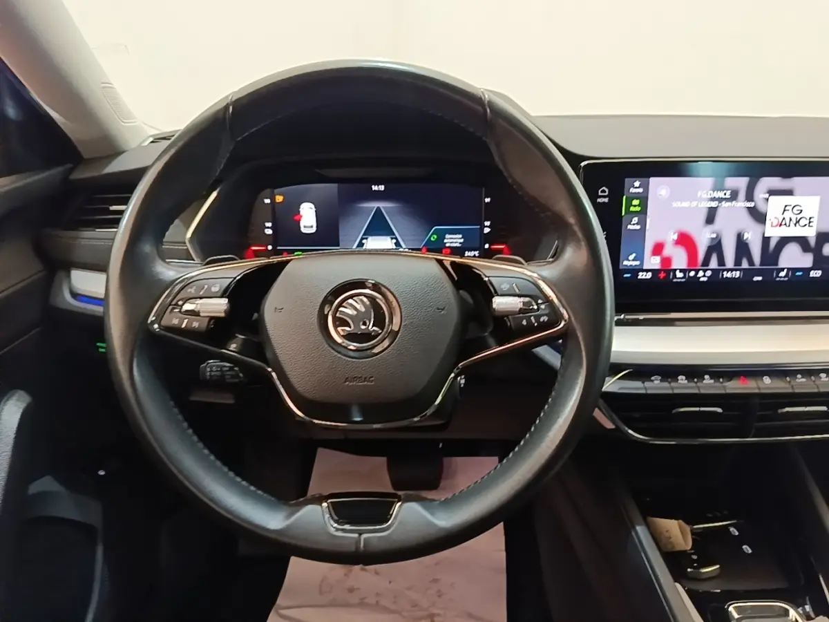 Vue intérieure centrée sur le volant cuir noir et les écrans digitaux du tableau de bord d'une Skoda Octavia 2022.