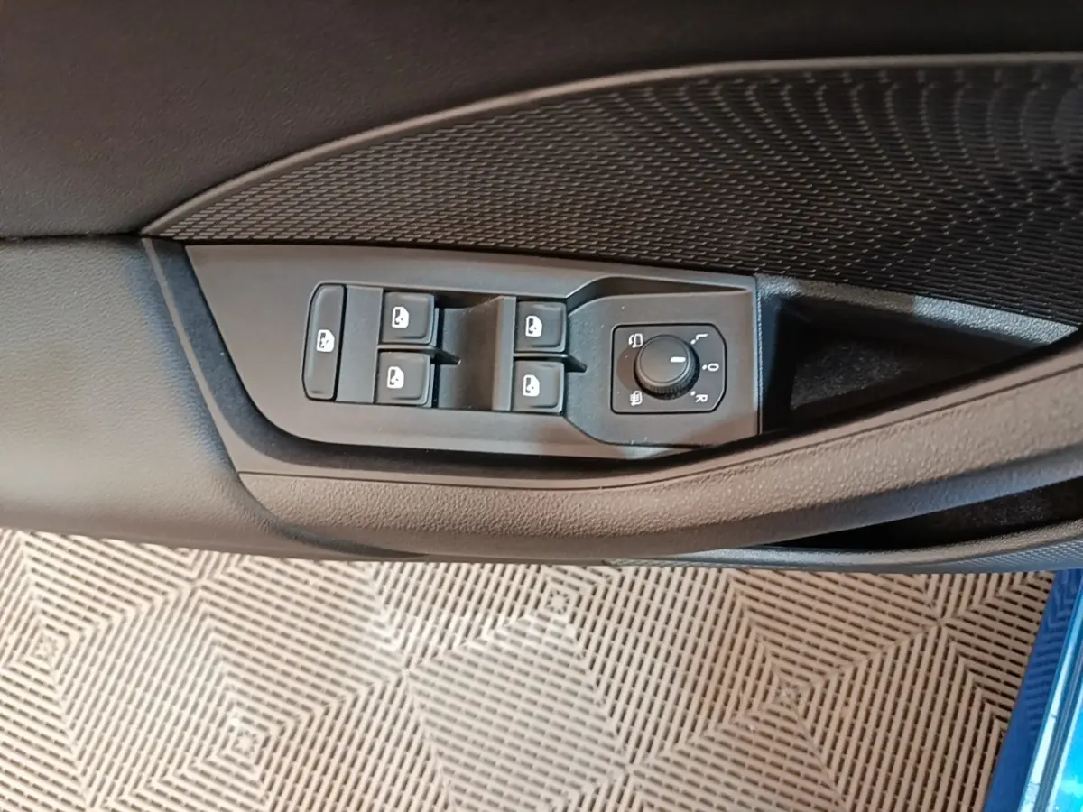 Commandes des vitres et réglage des rétroviseurs sur la porte côté conducteur d'une Skoda Octavia bleu 2022.