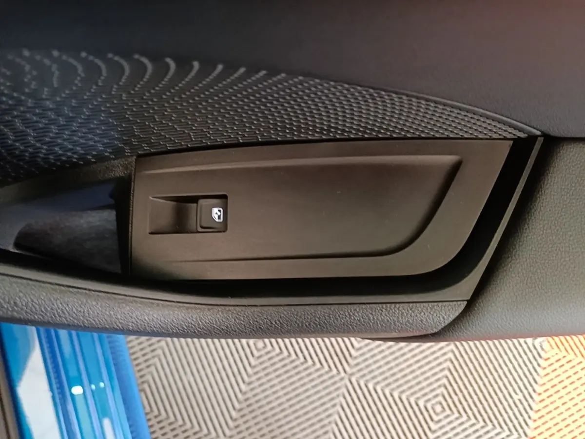 Détail de la commande de lève-vitre sur la porte côté conducteur d’une Skoda Octavia bleu 2022.