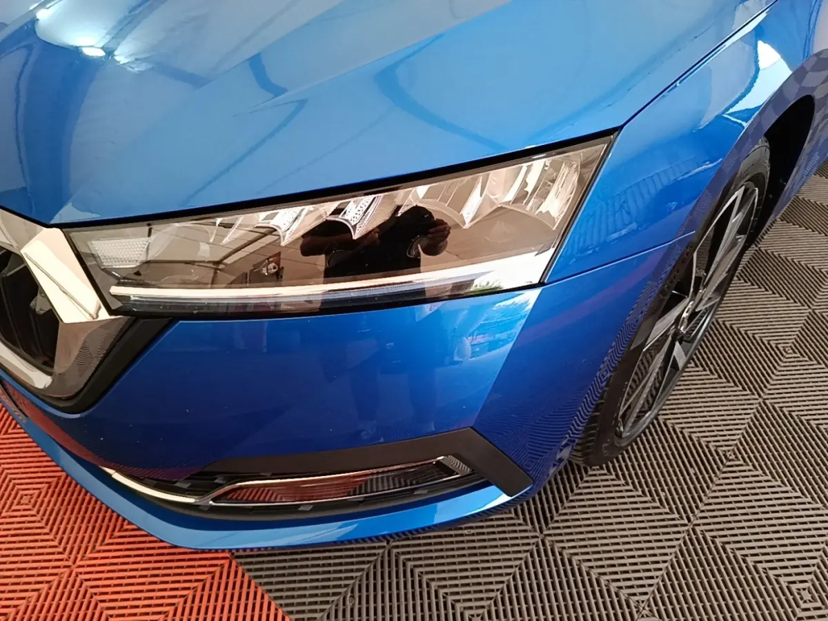 Gros plan sur l’avant droit bleu d’une Skoda Octavia 2022 avec phares LED et jante alliage visible.