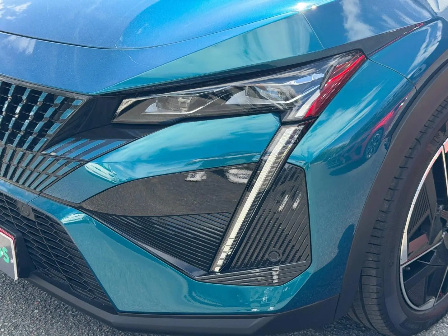 Gros plan sur l'avant droit bleu Obsession du Peugeot 408 Hybrid avec feux LED et jante alu noire.
