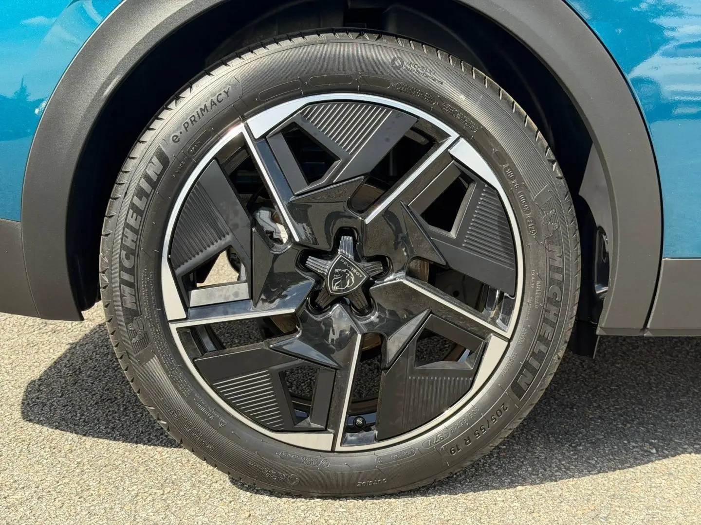 Gros plan sur la jante alu noire et argentée du côté avant droit d'une Peugeot 408 Hybrid Bleu Obsession.