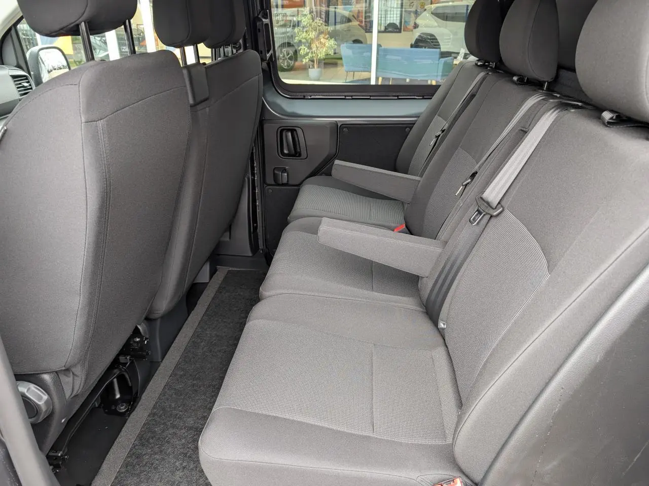 Banquette arrière grise avec accoudoirs rabattables côté droit du Citroën Jumpy cabine approfondie 2025.