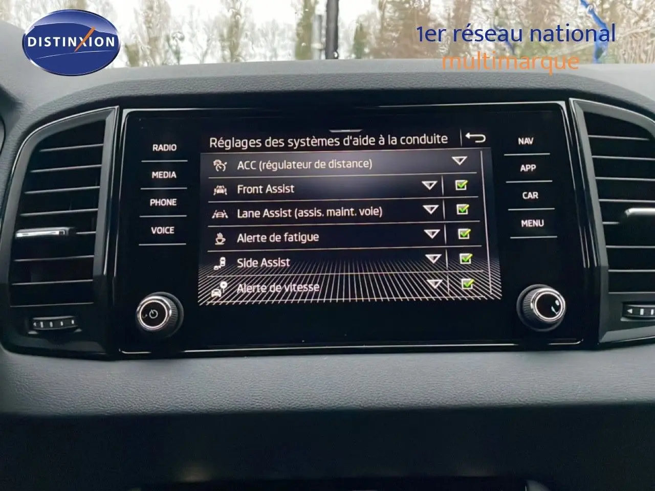 Écran central du tableau de bord du Skoda Karoq 2025 affichant les aides à la conduite, vue de face.