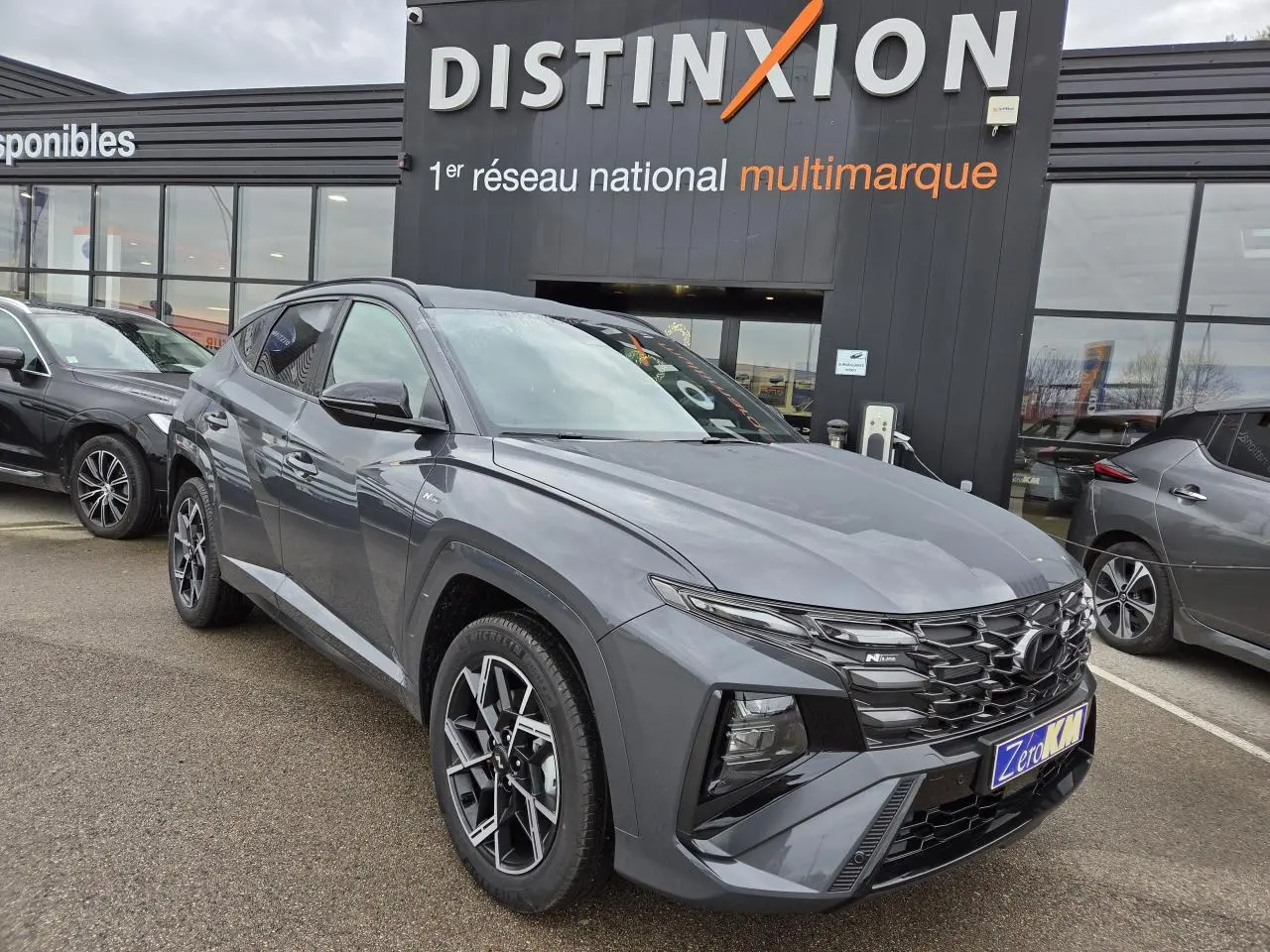 Hyundai Tucson 2025 gris métallisé en vue 3/4 avant, avec calandre N Line et jantes alliage 19 pouces.