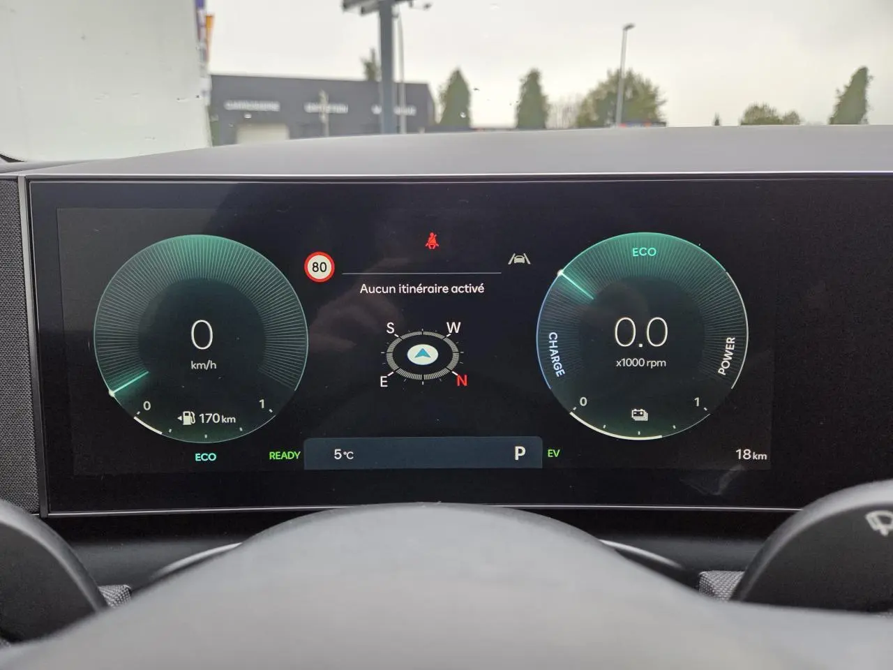 Vue intérieure du tableau de bord numérique du Hyundai Tucson gris, affichant vitesse, RPM et navigation.